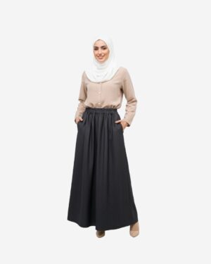 “Model wearing beige linen blouse tucked into a black denim skirt, showing the fitted waist and soft wrinkle-resistant linen fabric by Asmaa Basha.
